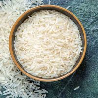 top-view-raw-rice-inside-plate-dark-desk